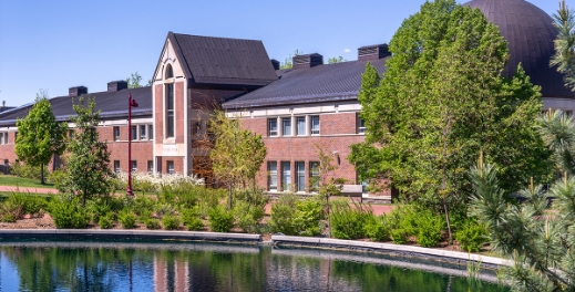 a building on campus with a pond in front